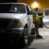 A person waits while filling their fuel tank at an Astro gas station on Wednesday, April 29, 2026, in Portland, Ore. (AP Photo/Jenny Kane)