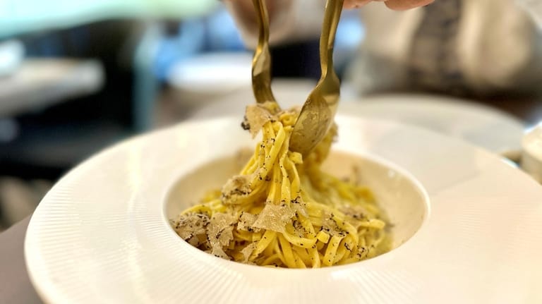 Tagliatelle is topped with Parmesan and black truffles.