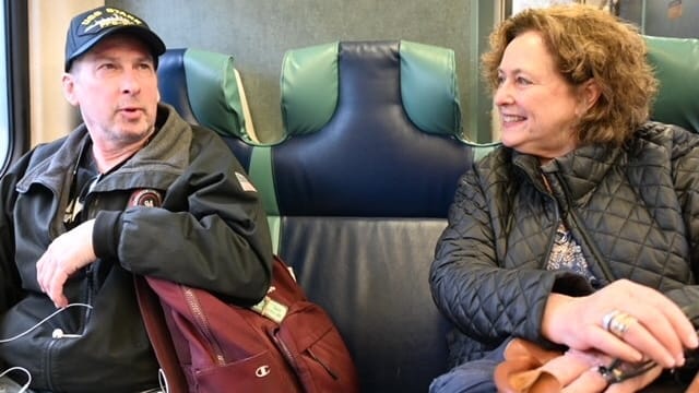 Raine Mackey, 69, of Westbury, chats on the train with Sean...