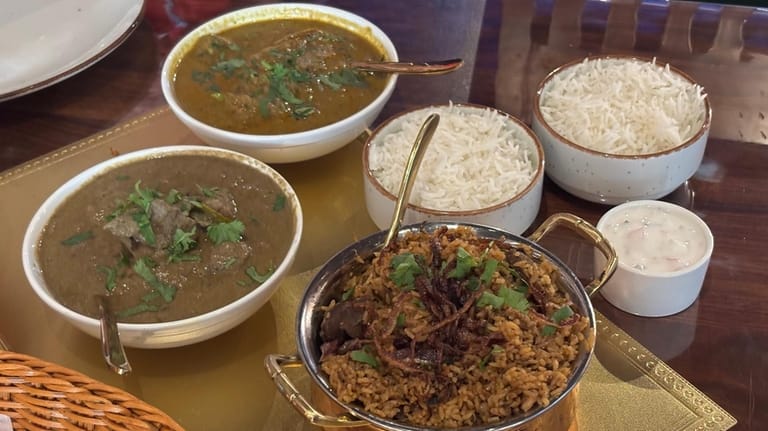 A pot of mutton biryani is paired with two curries,...