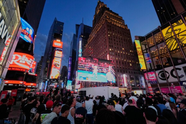 People gather in Times Square to watch a boxing match, May 2, 2025, in New York. (AP Photo/Frank Franklin II, File)