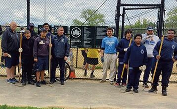 Volunteers came to Whitey Ford Field to clean out the dugout, remove divots from the ballfield, and rake the infield. Photo by Neil Herdan