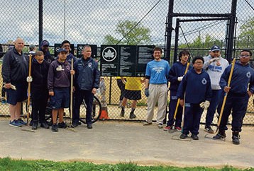 Volunteers came to Whitey Ford Field to clean out the dugout, remove divots from the ballfield, and rake the infield. Photo by Neil Herdan