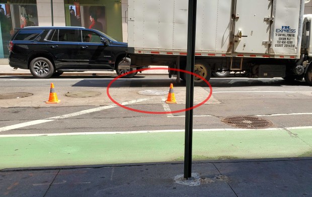 A 56-year-old woman died after falling into a manhole (circled) in Manhattan on Monday, May 18, 2026. (Nicholas Williams / New York Daily News)