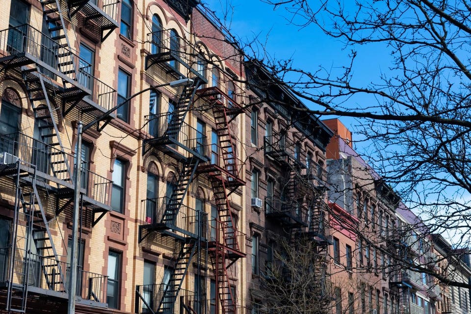 Row of Colorful Old Buildings with Fire Escapes in Harlem of New York City