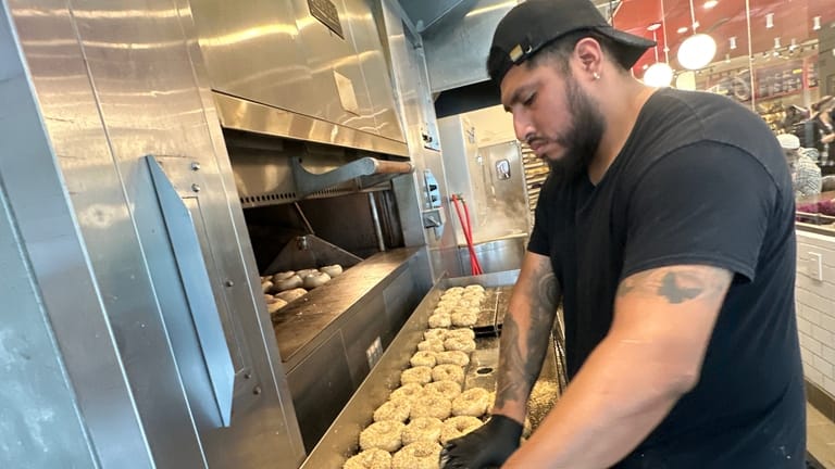 A worker at Utopia Bagel preps bagels made with bromated...