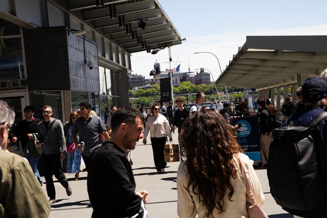 Commuters and tourists walking and purchasing tickets on a weekday morning at the Wall Street boat deck, in New York.