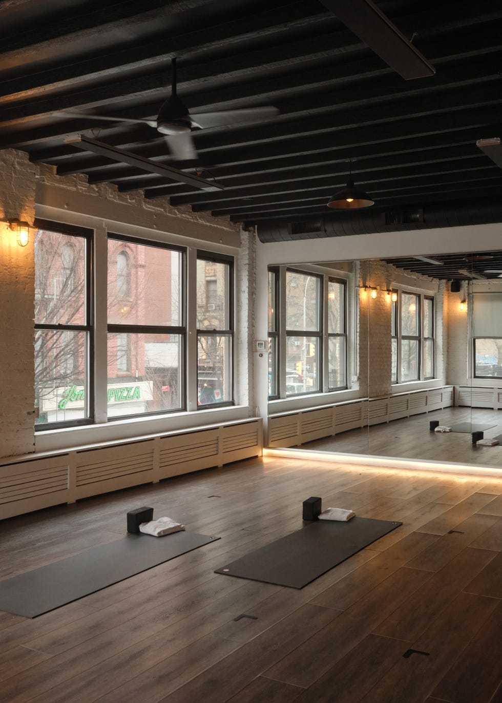 Yoga studio with two mats and large windows.