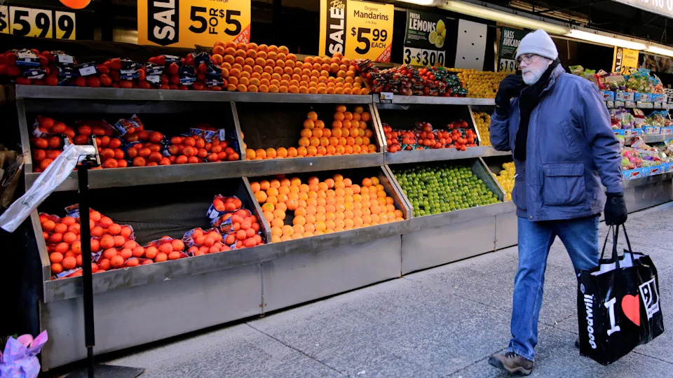 A man is seen walking past a grocery store in New York City.