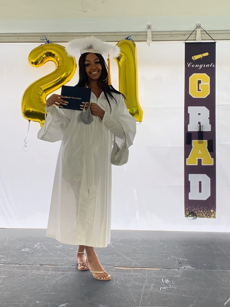 Kayla Wilson smiling in her graduation gown, holding her diploma with "Park Slope Collegiate" printed on it, with "21" balloons and a "Congrats GRAD" banner in the background.
