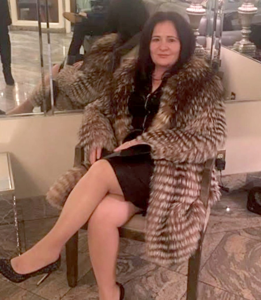 Donika Gocaj sitting and wearing a fur coat.