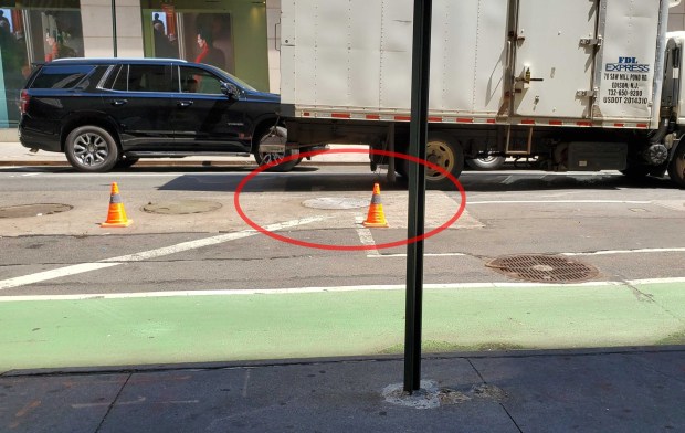 A 56-year-old woman died after falling into a manhole (circled) in Manhattan on Monday, May 18, 2026. (Nicholas Williams / New York Daily News)