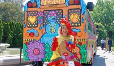 Artist Carmen Paulino stands beside one of the psychedelic buses featured in the &ldquo;Flower Power&rdquo; exhibit, this one created by artist Snoeman.