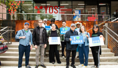 Building 92 entrance at the Brooklyn Navy Yard, left to right: Hunter Armstrong of the Brooklyn Greenway Initiative; Adam Ganser, executive director of New Yorkers for Parks; Ethan Mulligan of the Brooklyn Navy Yard; Rene Scotland, founding member of Friends of Commodore Barry Park; Rosamond Fletcher of the Fort Greene Park Conservancy; Brit Byrd, senior planner for Brooklyn Borough President Antonio Reynoso; Henry Gutman, Brooklyn Navy Yard Board chair; Emily Weidenhof, assistant commissioner for the Office of Liveable Streets; Kathy Park Price of New Yorkers For Parks. Photo: Julie Thompson/Brooklyn Eagle