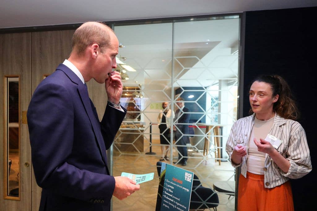 Britain's Prince William, Prince of Wales (L) tastes a snack made of seaweed during a visit to the ZERO2FIVE Food Industry Centre, to celebrate the seaweed industry and food innovation in Wales on June 11, 2024 in Cardiff, Wales