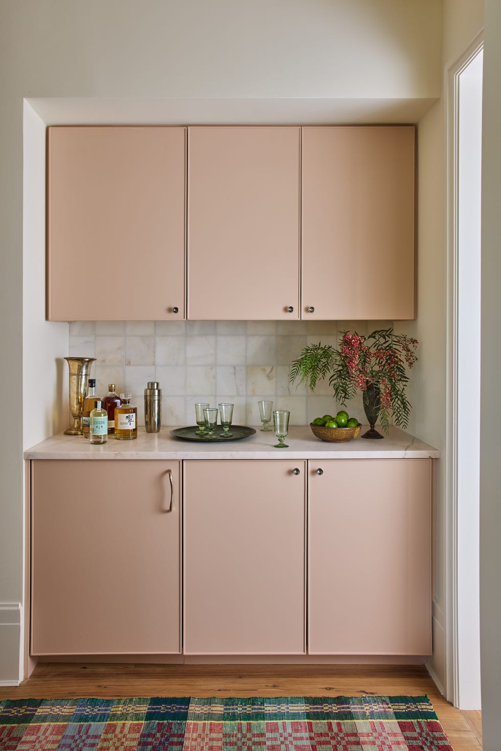 Modern kitchen area featuring a bar cabinet with drinks and decorative elements.