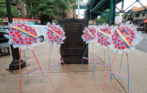 Wreaths at the Woodside Memorial Park Triangle at the corner of Woodside and Roo­sevelt Avenues. Photos Walter Karling