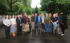 Participants posed by the Doughboy statue before leaving the park. Some seen here: (at far left, l to r): Councilwoman Julie Won, Congresswoman Grace Meng, Assem­blyman Steven Raga, Colonel Marissa Pace (center in US Army uniform), and (at far right) congressional candidate Melvin Rivera.
