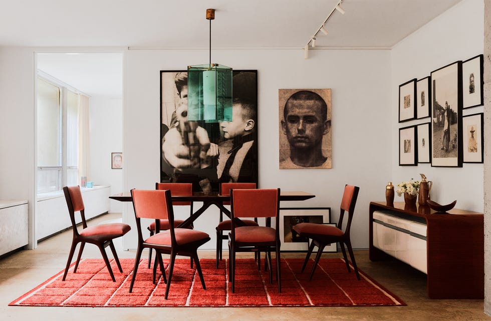 Modern dining area with a table and chairs, featuring artwork on the walls.