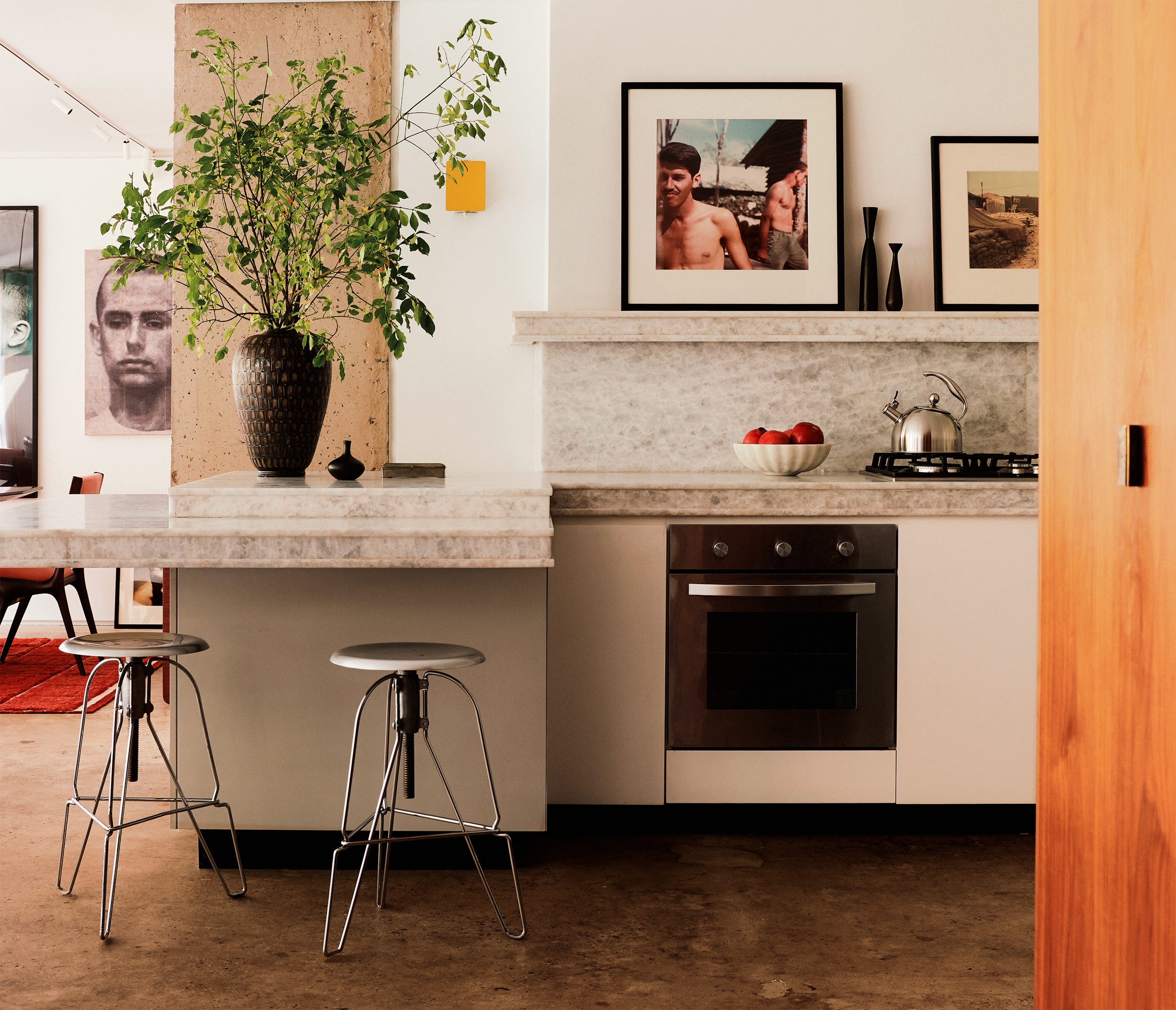 Modern kitchen featuring a large island, minimalist decor, and wall art.