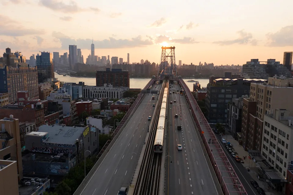 Anadolu Agency via Getty Images, FILE - PHOTO: In this July 28, 2021 file photo, a subway train crosses the Williamsburg Bridge in New York.