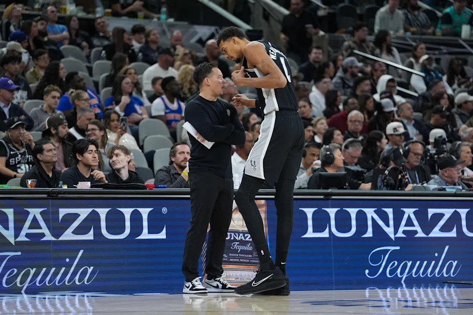 San Antonio Spurs head coach Mitch Johnson talks with Victor Wembanyama in the second half against the New York Knicks at Frost Bank Center.