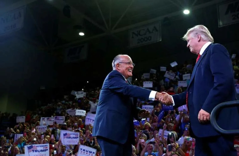 Former New York mayor Rudy Giuliani greets Republican U.S. presidential nominee Donald Trump at the Trask Coliseum at University of North Carolina in Wilmington, North Carolina, U.S., August 9, 2016 (credit: REUTERS)