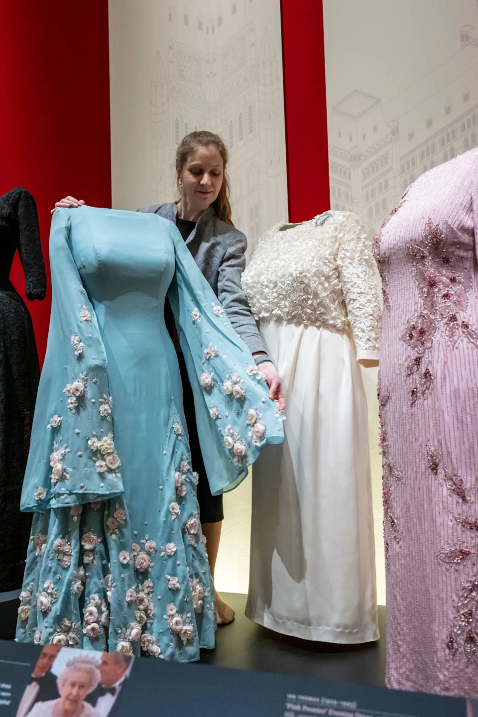 Royal Collection curator with 'Cherry Blossom' Evening Dress, 1975, Silk, silk chiffon, crystals, sequins, by Norman Hartnell worn during the first visit by the reigning British monarch to Japan and other evening dresses at a preview of Queen Elizabeth II: Her Life in Style, exhibition at The King?s Gallery, Buckingham Palace