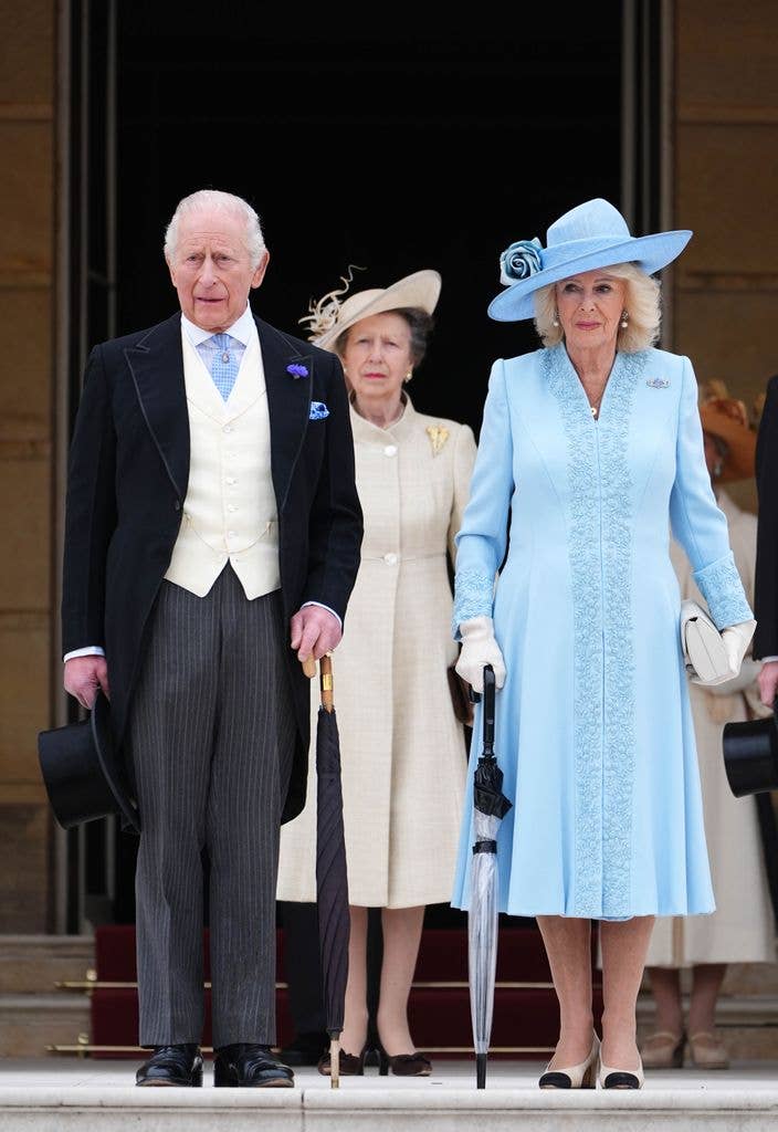 King Charles standing with Princess Anne and Queen Camilla
