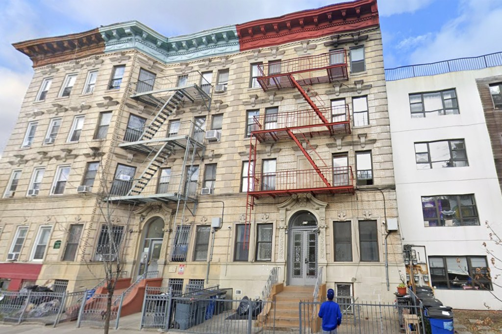 Residential buildings with fire escapes and a man in a blue shirt.