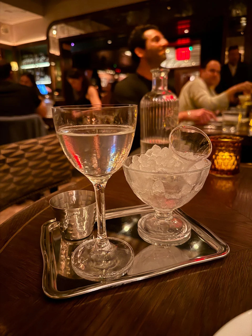 Serving tray with a cocktail, an ice bowl, and a silver cup.