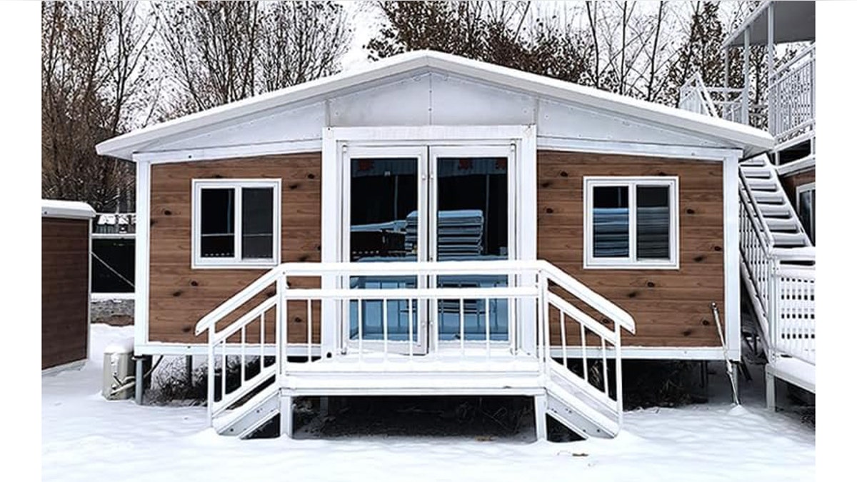 A small modern tiny home with large windows and a porch.