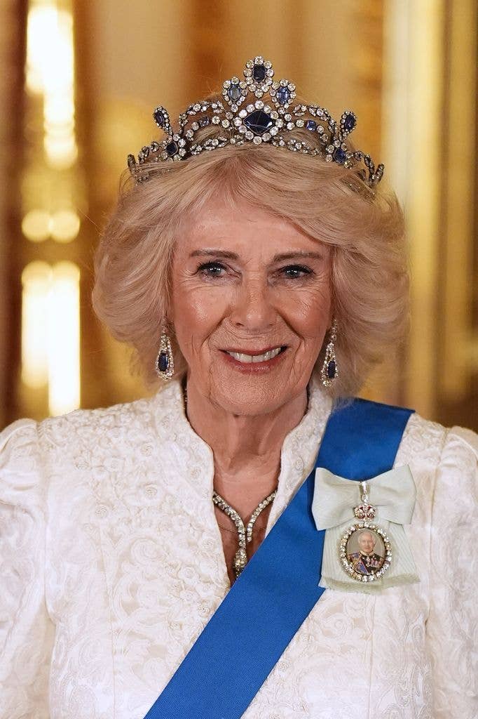 Queen Camilla in a white dress with a sapphire tiara