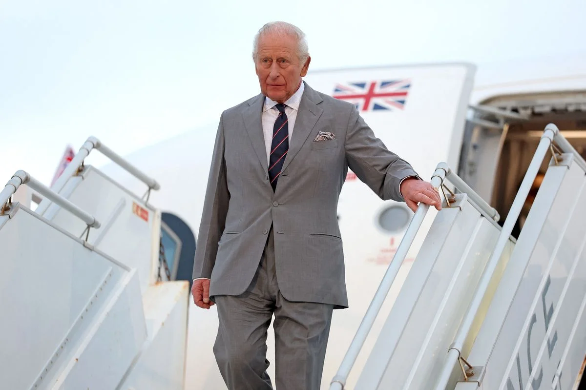 King Charles III descends from the aircraft upon arrival in Bermuda, marking a historic first visit as monarch.