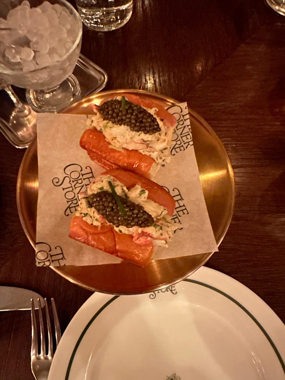 Gourmet lobster rolls served with caviar on a gold plate.