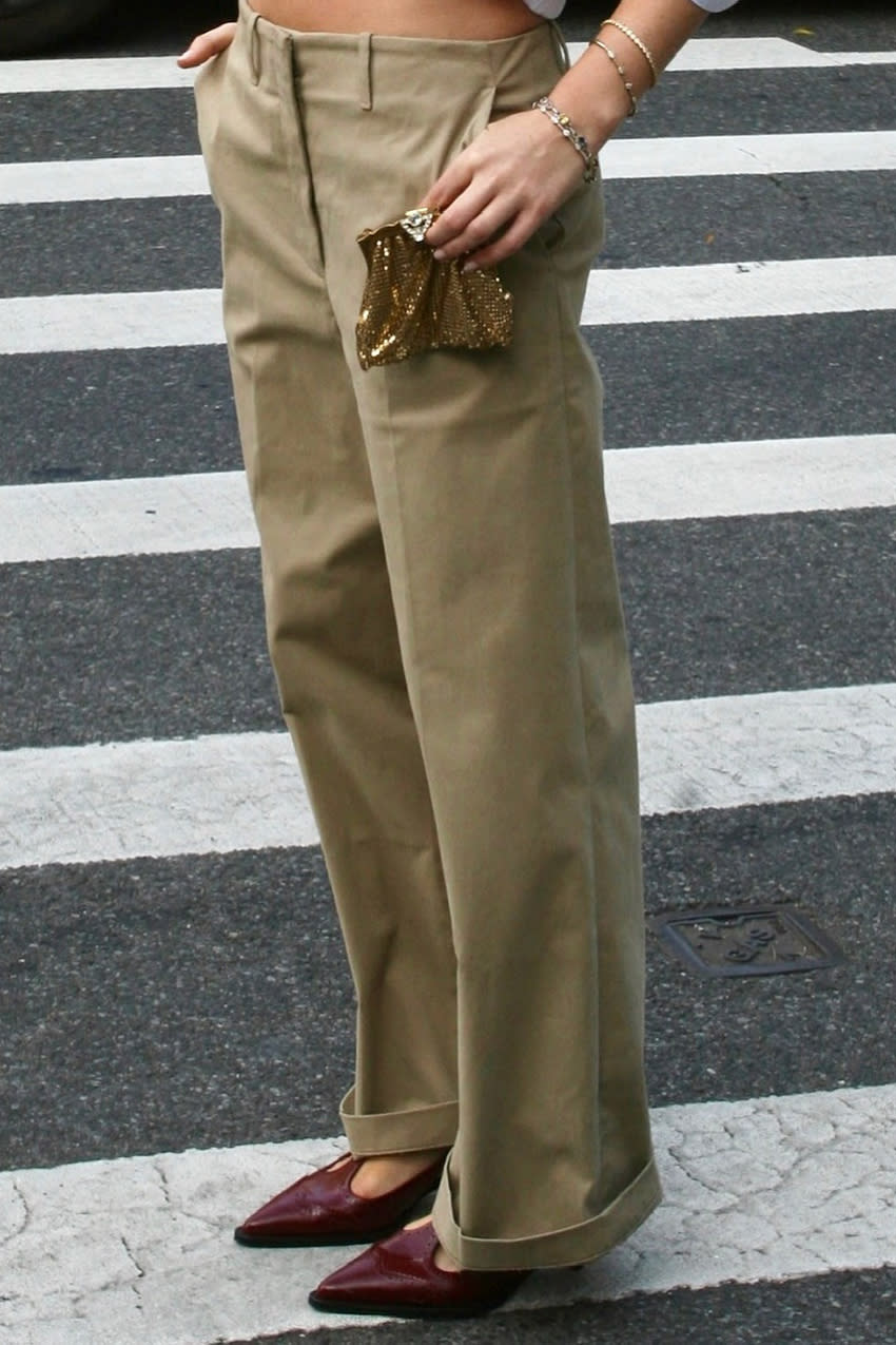 a woman wearing a pair of khaki pants with burgundy t-strap heels