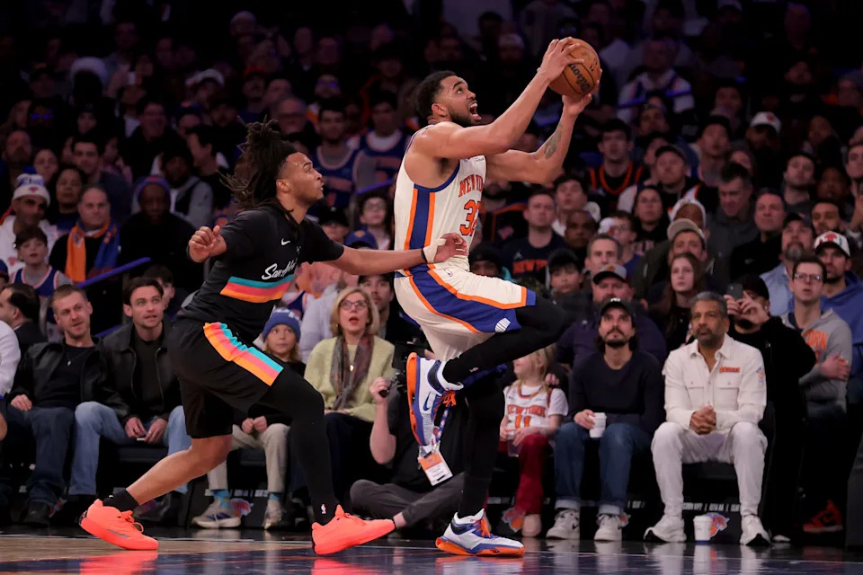 New York Knicks center Karl-Anthony Towns (32) drives to the basket against San Antonio Spurs guard Stephon Castle.