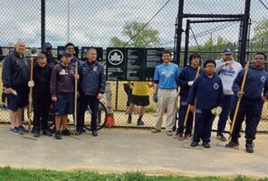 Volunteers came to Whitey Ford Field to clean out the dugout, remove divots from the ballfield, and rake the infield. Photo by Neil Herdan