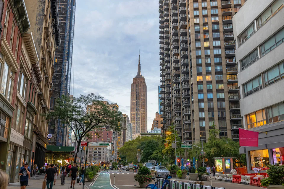 New York. USA. September 21.2022. Beautiful view of Empire State Building in New York on background of city street and evening skyline.