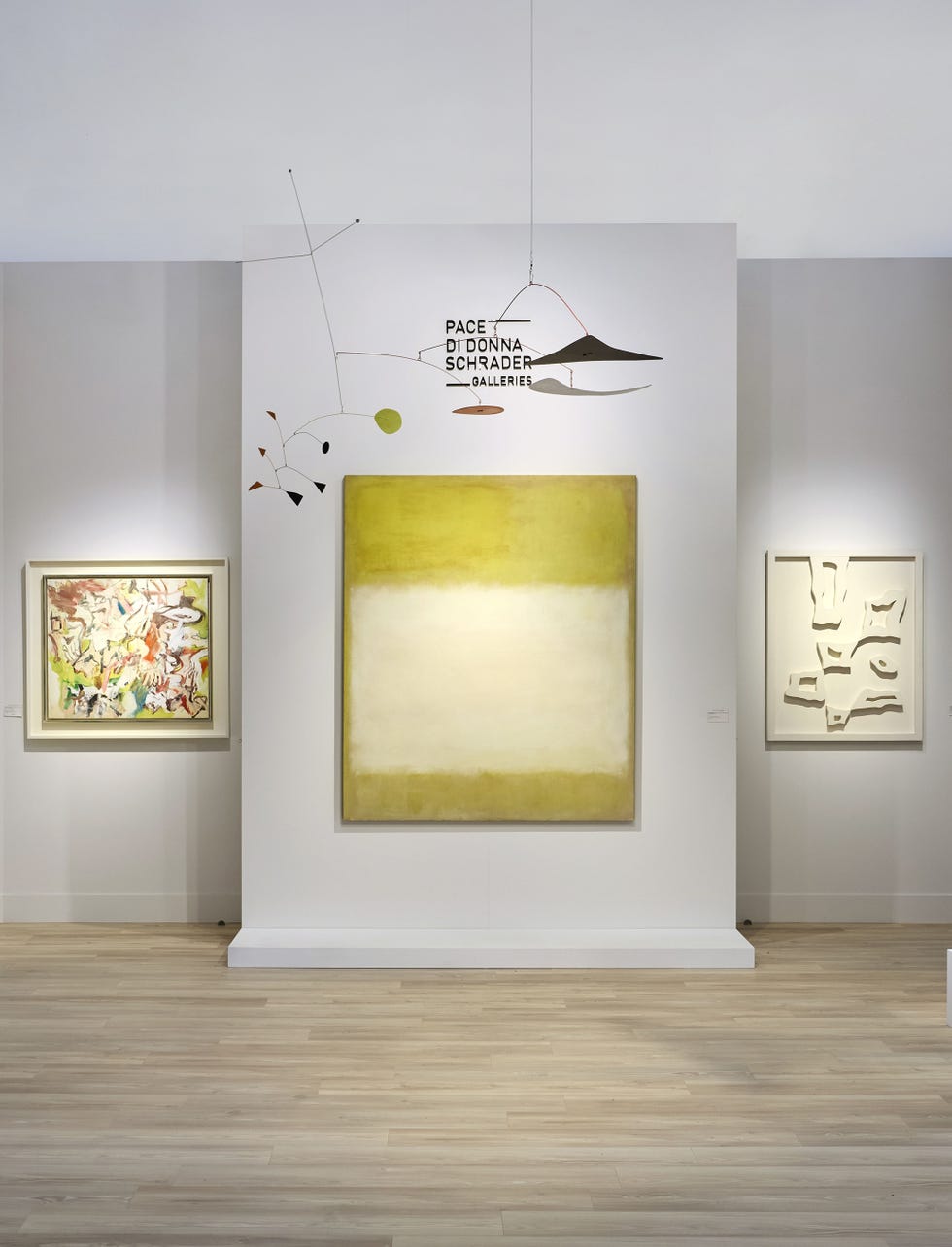 Art gallery featuring three abstract artworks and a mobile installation.