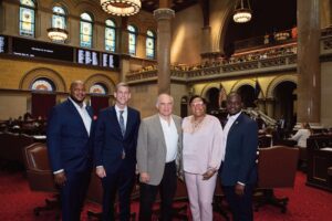 (L. to r.): Aaron Ambrose, Queens Regional Representative for Governor Hochul; Assemblyman Braunstein, Ron Naclerio, and Assemblymembers Hooks and Ander­son are photographed on the Assembly Floor.