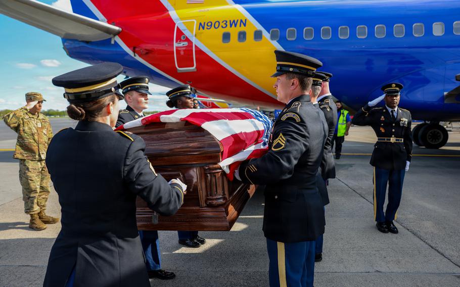 New York National Guard soldiers carry a casket draped with the American flag from a Southwest airplane.