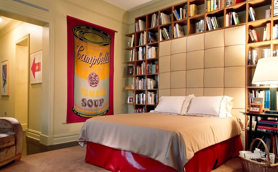Bedroom featuring a Campbell's soup banner and a bookshelf.