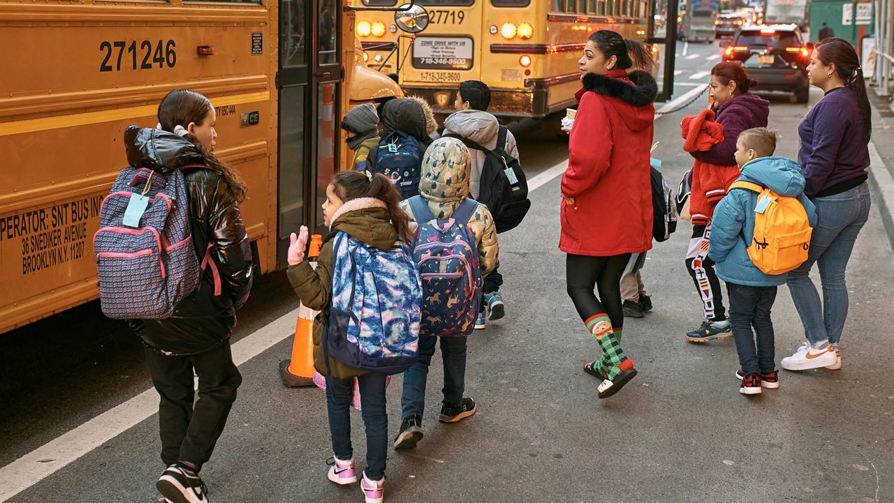 Students take the school buses on Tuesday, Dec. 12, 2023, in New York. (AP Photo/Andres Kudacki)