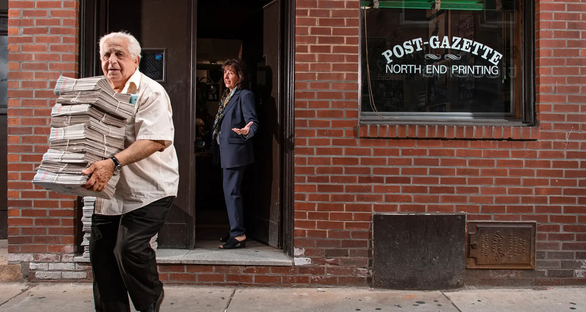 This photo provided by Ann Hermes shows Louie Graffeo delivering copies of The Post-Gazette for his girlfriend, publisher and editor, Pamela Donnaruma, in Boston on June 8, 2023. Photo: Ann Hermes via AP