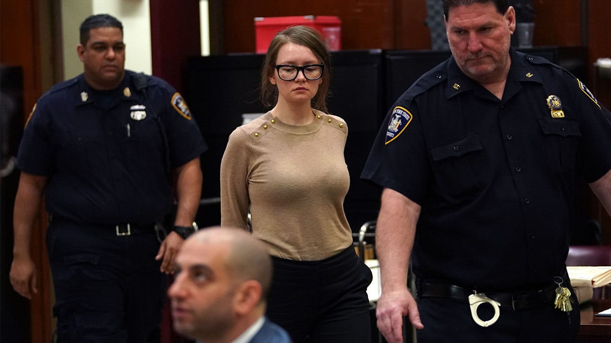 Anna Sorokin wearing a beige sweater seated in a courtroom