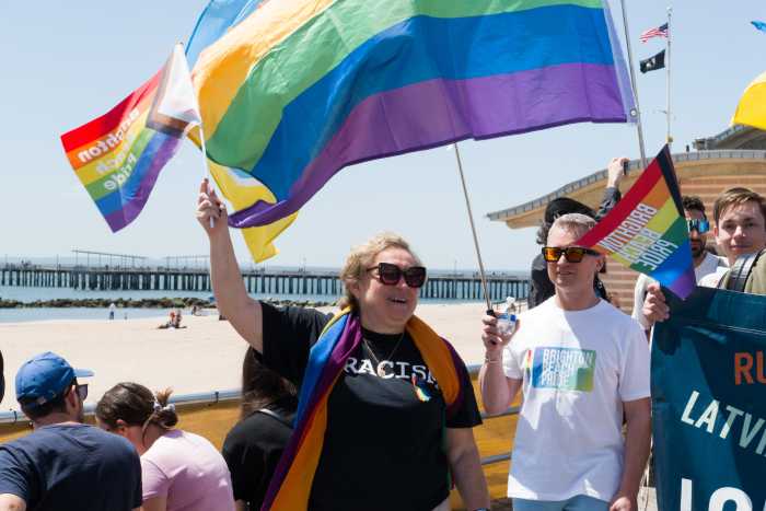 Yelena Goltsman, founder and president of the board of Qaravan, waves a Rainbow Flag.