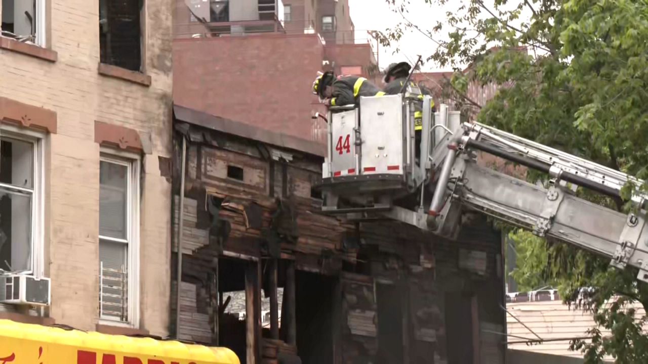 fireneb outside a building on a crane near damaged building