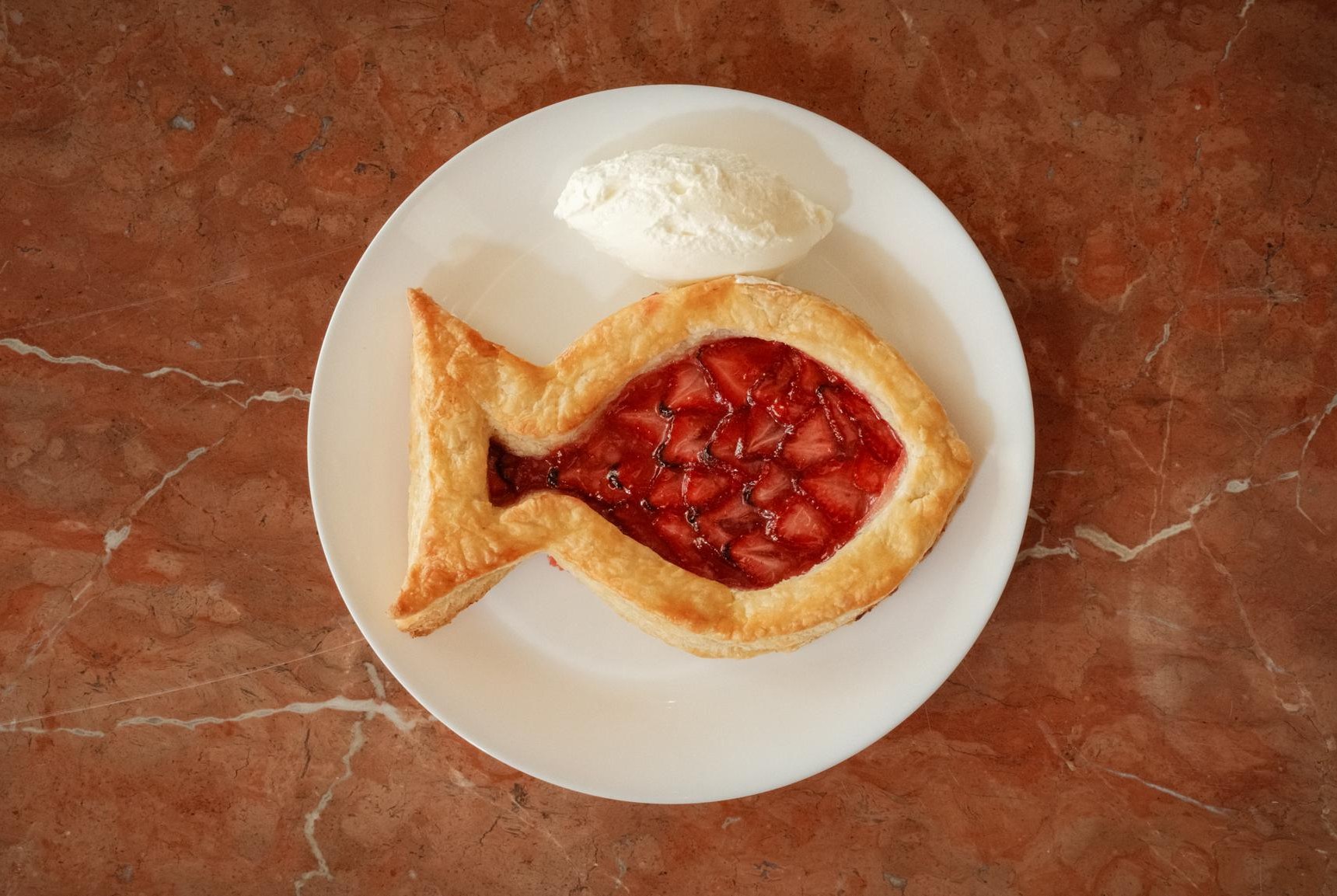 A fish-shaped pie with strawberries in the middle.