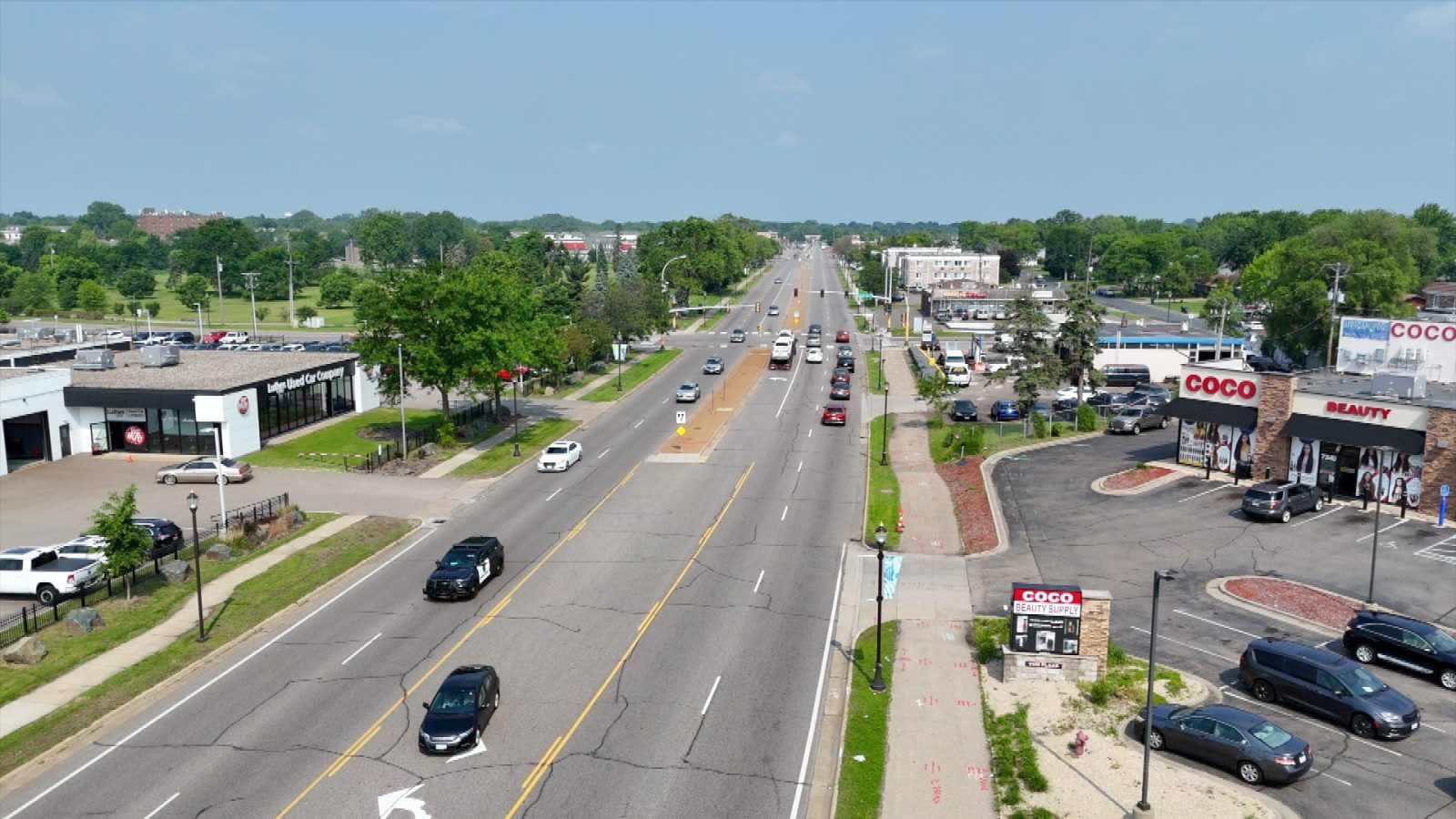 busy boulevard corridor lined with businesses and trees